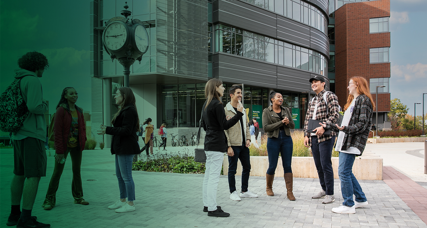 A group of Ƶ students converse around the clock in the center of Wilkins Plaza.